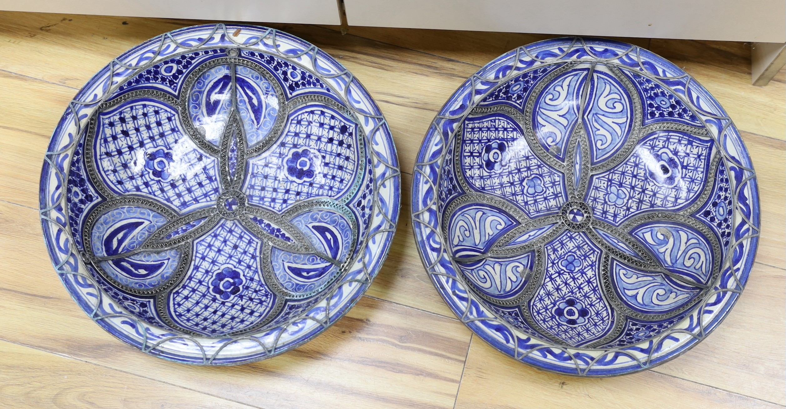 A pair of Moroccan metal bound pottery dishes, 39cm diameter